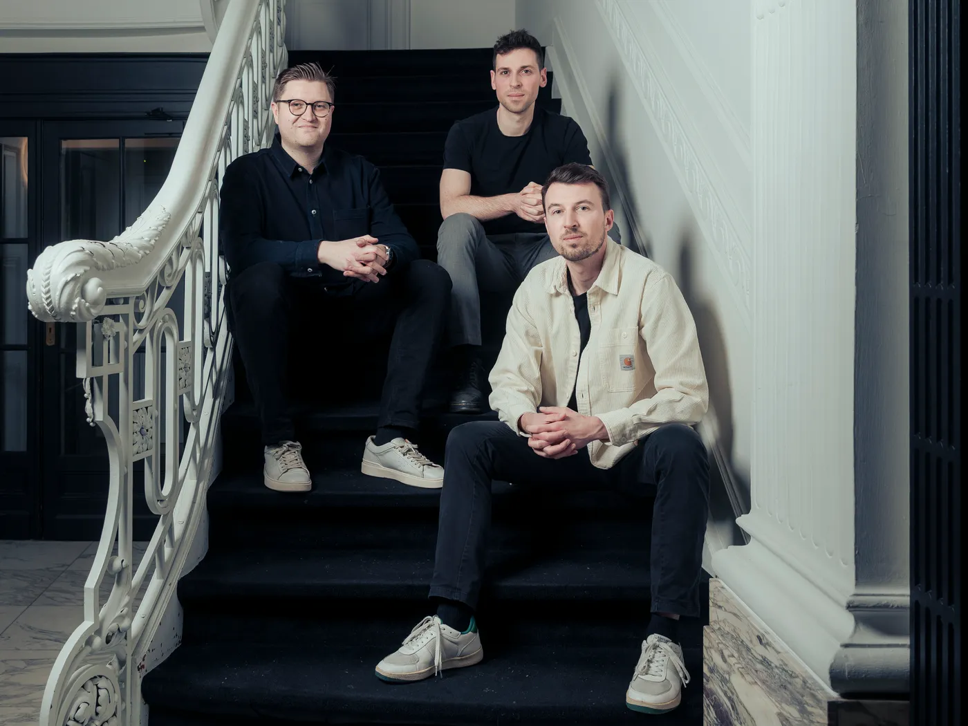 Thomas Aertgeerts, Anton Van Uytsel en Ruben Aertgeerts op de trap van het kantoor in Leuven