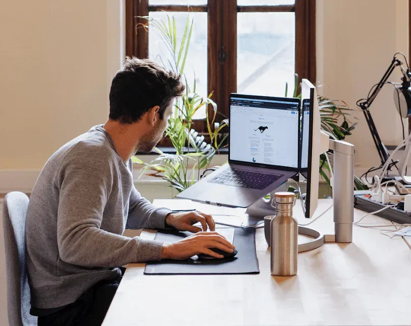 Een Astro-collega werkt aan het platform, aan zijn bureau bij het raam